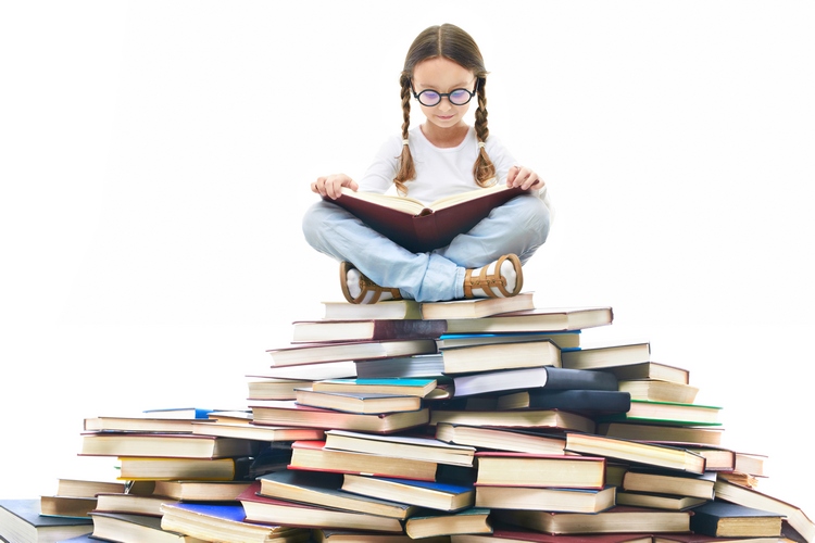 Pile of books with girl on top reading